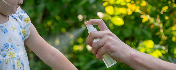 istock Father applying insect repellent spray to child's hand outdoors. Selective focus 2235388868