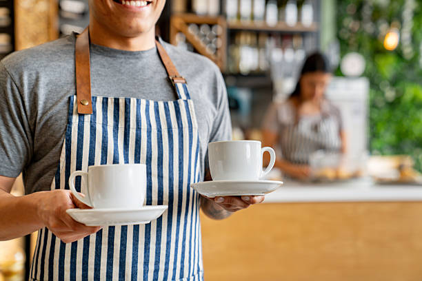 istock Waiter serving a cup of coffee at a cafe 2235389182