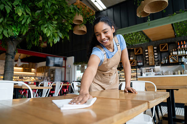 istock Waitress cleaning a table at a coffee shop 2235389220