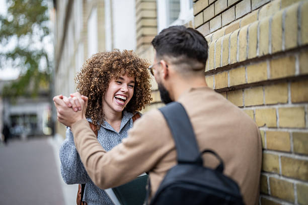 istock University students shaking hands and laughing together 2235390479