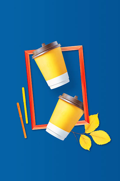 Autumn Composition With Coffee Cups And Frame On Blue Background. Concept of Seasonal Coffee To Go, Cozy Autumn Vibes, Bright Food And Drink Design, Creative Cafe Promotion, Modern Lifestyle Visuals