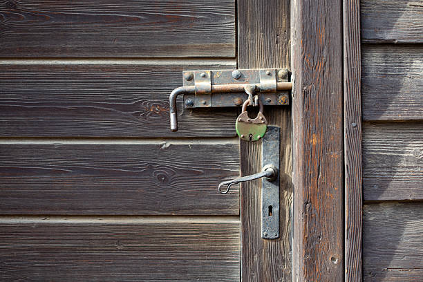 istock Rustic weathered wooden door with old metal lock and handle. 2235394372