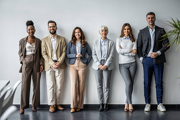istock Diverse business team smiling together against white wall 2235402553