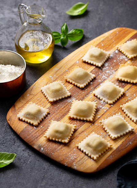 Ravioli on a wooden board. Grey background. Close up.