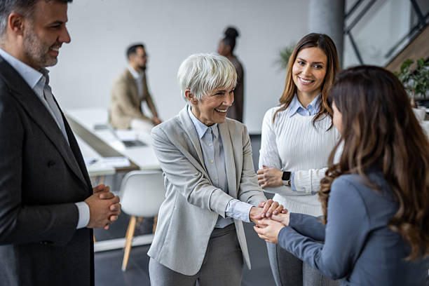 istock Business team showing support and unity holding hands in the office 2235405309
