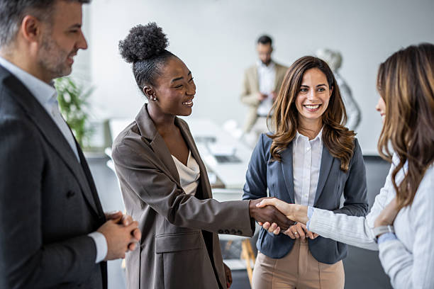 istock Businesswomen shaking hands during meeting in modern office 2235405342