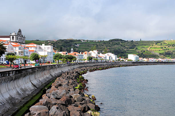 Horta, Faial Island, Azores, Portugal: Horta is situated on the southeastern shore of Faial Island within a sheltered bay that has historically facilitated its role as a transatlantic waypoint, with a population of 15.000 residents, of which approximately 7,000 reside in the urban parishes of Angústias, Conceição, and Matriz. Settlement commenced around 1467 under Flemish nobleman Josse van Huerter, who established a chapel and community that evolved into a town by 1498 under King Manuel I, bolstered by Portuguese and Flemish immigrants focused on agriculture, including woad dyes, oranges, and wines from neighboring Pico Island; by the 19th century, Horta's port supported whaling fleets, submarine telegraph cables from 1893, and aviation milestones such as the first transatlantic seaplane landing in 1919, cementing its cosmopolitan identity. Architecturally, the city features volcanic basalt constructions such as the 16th-century Fort of Santa Cruz, the Baroque Igreja Matriz do São Salvador with its Joanino altarpieces and azulejo tiles, and the 17th-century Igreja do Carmo, alongside the iconic Marina of Horta. Today, Horta's economy centers on tourism, including whale-watching and cultural festivals, alongside agriculture, fisheries, and port activities.