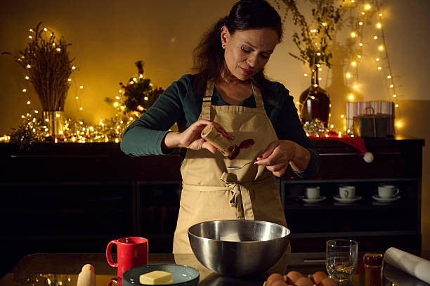istock Woman Baking Cookies in a Festive Kitchen with Christmas Lights 2235409873