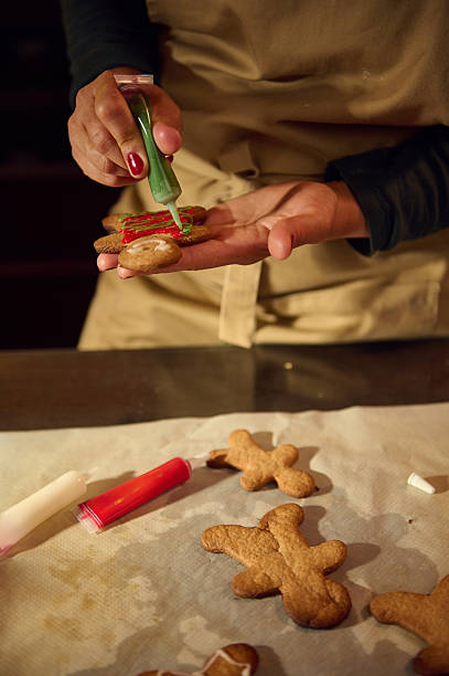 istock Decorating Gingerbread Cookies for Christmas Holidays in a Festive Kitchen 2235409925