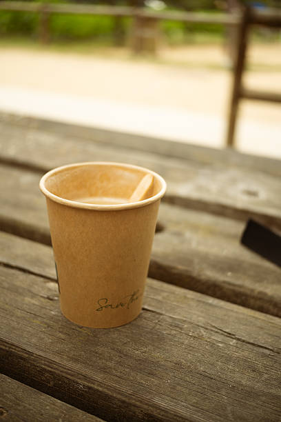 istock Person checking phone in park while drinking coffee. 2235411182