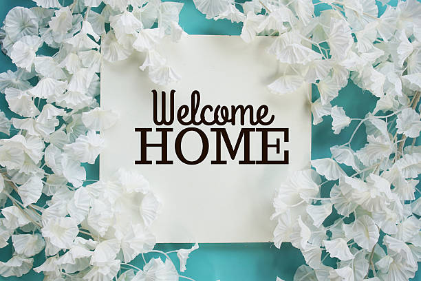 istock Welcome Home text with flowers frame decoration top view on blue background, 2235411891