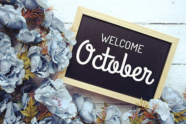 istock Welcome October text with flowers frame decoration top view on wooden background, 2235411921