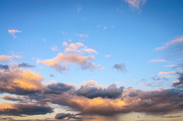 Beautiful sky with yellow clouds illuminated by sunset golden light