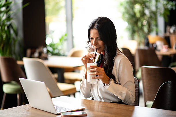 istock Woman drinking latte while working on laptop 2235412846