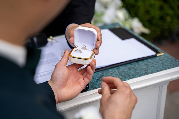 istock Groom holding wedding rings in a box during ceremony. 2235414205