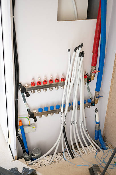 istock Underfloor heating manifold system with labeled pipes, flow meters, and supply connections in utility room installation. 2235415664