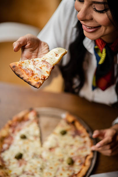 istock Beautiful woman smiling with pizza slice 2235421664