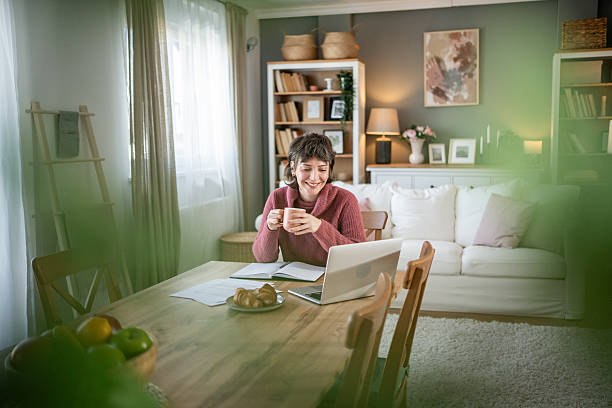 istock Young woman working remotely from home drinking tea 2235423049