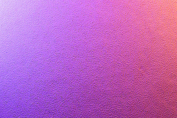 A close-up photograph of an abstract, textured surface with a smooth gradient from vibrant purple on the left to warm orange on the right. The image's rough, grainy texture contrasts with the soft color transition, making it a dynamic and modern backdrop for creative and digital projects.