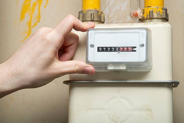 istock Gas boiler meter. A man is watching the meter. 2235429478
