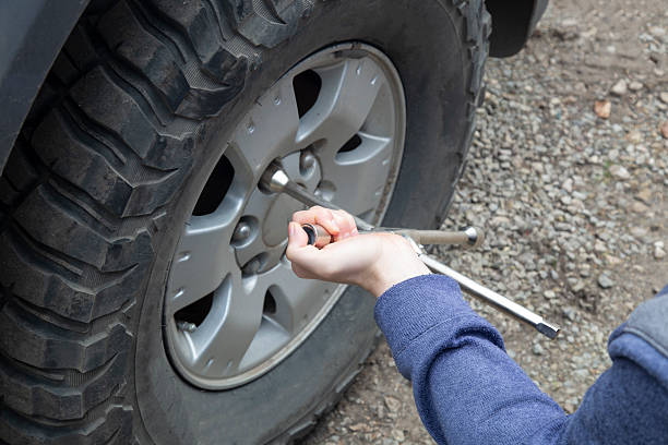 istock A man removes a wheel from a car using a wrench. 2235429825