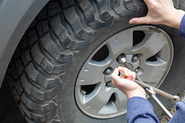 istock A man removes a wheel from a car using a wrench. 2235429826