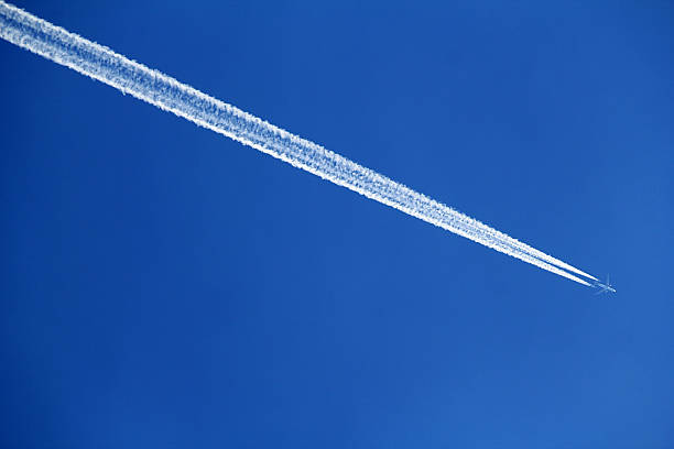 istock An airplane leaves a long contrail across a clear blue sky 2235429935