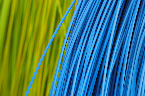 A close-up photograph of a detailed, abstract pattern formed by a bundle of brown wires or cables. The vertical, parallel lines create a sense of order and texture. The sharp focus on the foreground contrasts with a blurry, bright yellow background, making the image ideal for projects related to electricity, technology, industrial design, or as a modern, abstract backdrop.