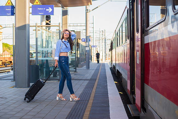 istock Young happy woman traveling with suitcase and backpack using train 2235436198