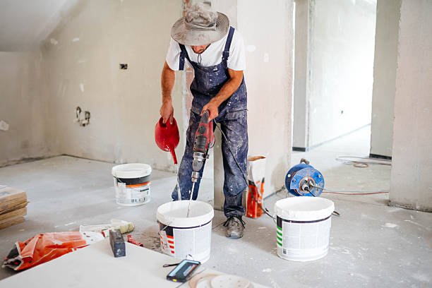istock Mixing concrete with tile adhesive mixing machine in a bucket 2235436343