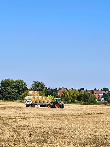 istock Harvesting: tractor with trailer full of hay 2235438712