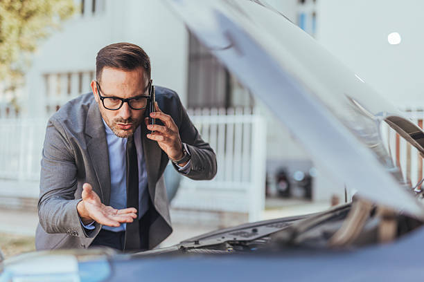 istock Businessman Stranded with Car Malfunction Talking on Phone in Frustration 2235440088