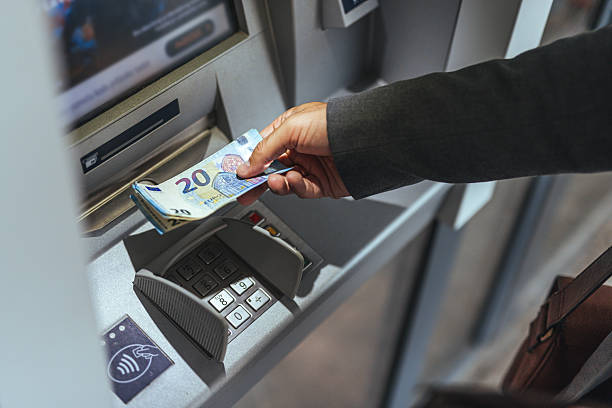 istock Close-Up of Hands Withdrawing Money From an ATM Machine 2235440125