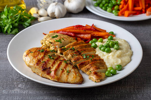 istock Grilled chicken breast slices served with mashed potatoes and vegetables. 2235440409