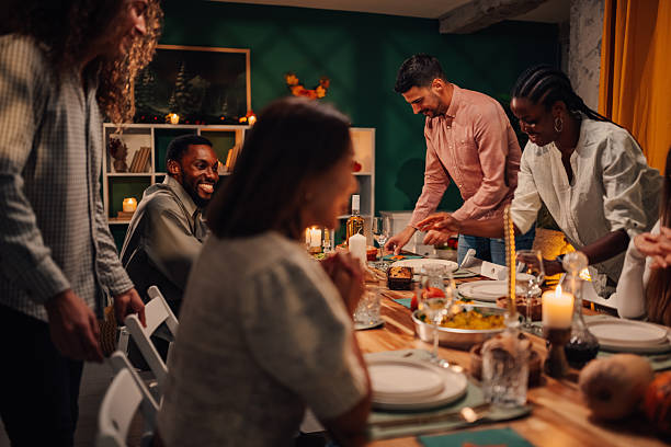 istock Friends preparing thanksgiving dinner table together at home 2235444117