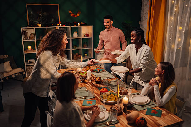 istock Friends serving food at thanksgiving dinner table 2235444122
