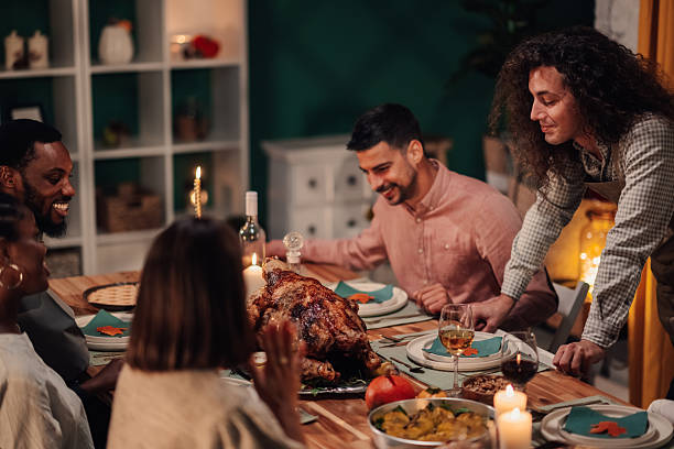 istock Friends enjoying thanksgiving dinner together at home 2235444161