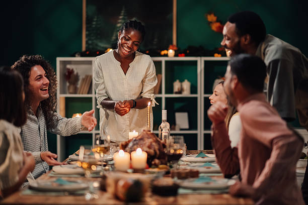 istock Friends lighting candles and enjoying thanksgiving dinner together 2235444176