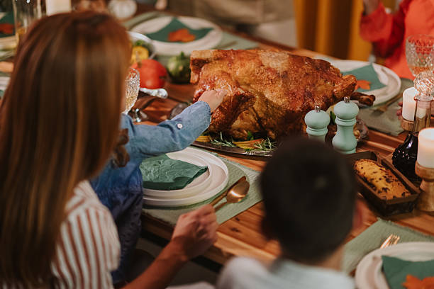 istock Family enjoying thanksgiving dinner with roasted turkey 2235444564