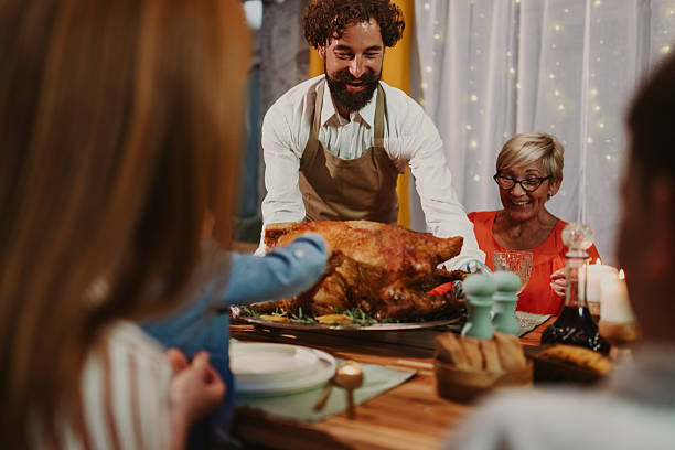 istock Family enjoying thanksgiving dinner with roasted turkey 2235444569