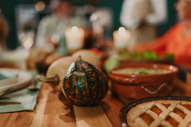 Family gathering around a wooden table, sharing a festive thanksgiving dinner filled with pumpkins, pie, and glowing candles, creating warmth and togetherness