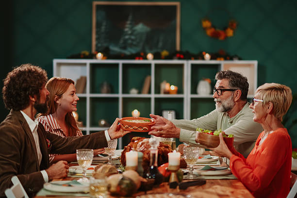 istock Family exchanging dishes during thanksgiving dinner at home 2235444599