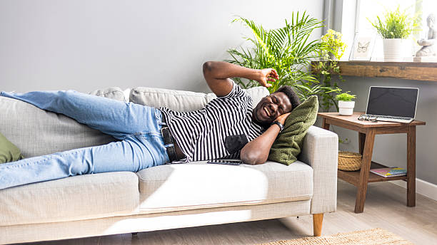 istock Relaxed Young Man Stretching on a Comfortable Couch in Cozy Bright Apartment 2235444800