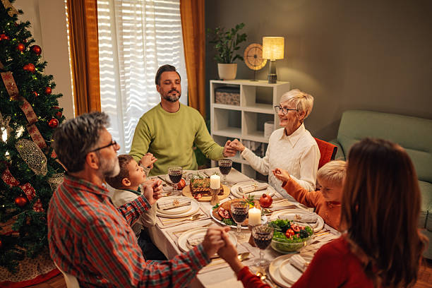 istock Family praying before christmas dinner at home 2235445908