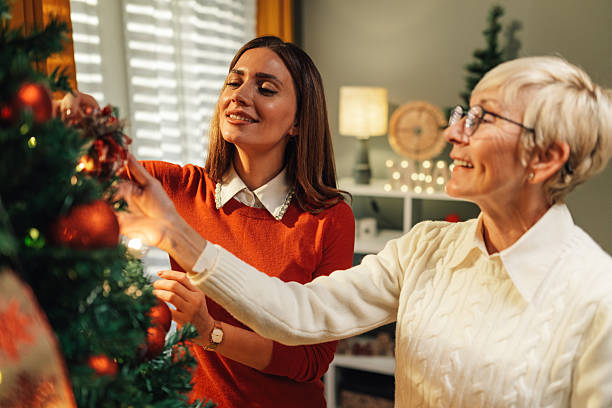 istock Women decorating christmas tree together at home 2235446113