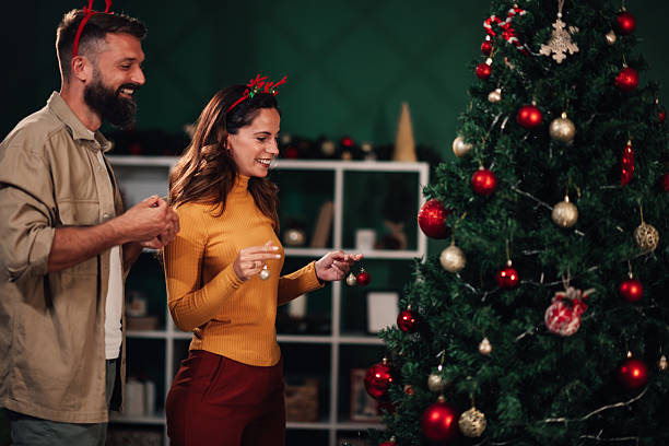 istock Couple decorating christmas tree together at home 2235447152