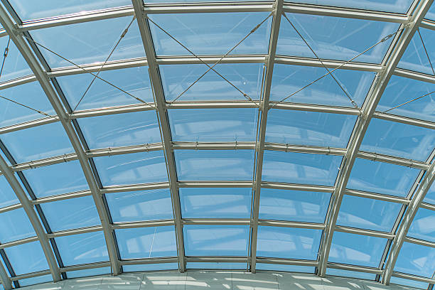 istock Spacious interior with a translucent, geometric ceiling structure made of tinted glass panels Natural light enters through the roof, casting soft shadows and creating a warm atmosphere contrasting c 2235447216