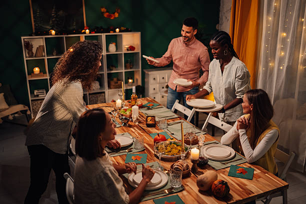 istock Friends setting thanksgiving table enjoying festive dinner together 2235447368