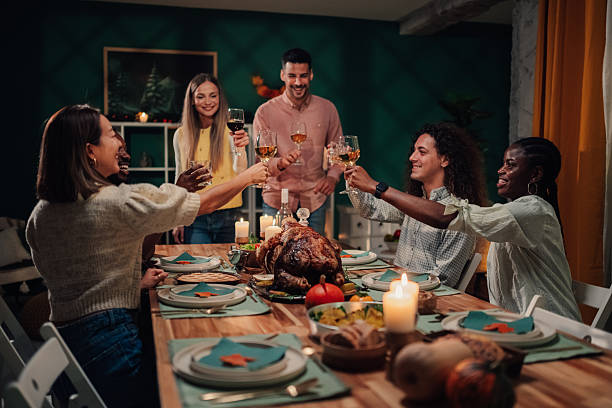 istock Friends toasting with wine at thanksgiving dinner table 2235447427