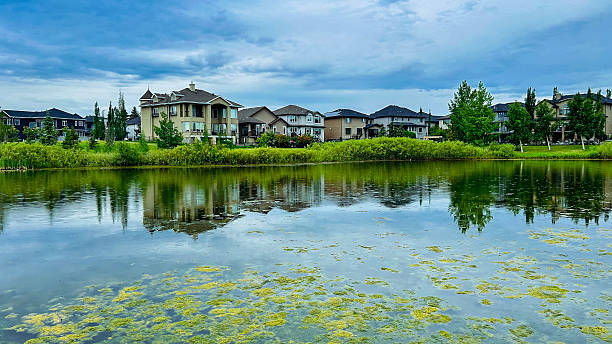 istock Luxury Homes Reflected in Calm Lake Waters Alberta Residential Development 2235447703